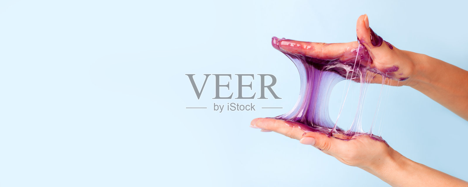 年轻女孩的手与粘紫色粘液在蓝色的背景，液体蜡脱毛，概念传单横幅与副本空间，抗压力放松，现代孩子的爱好奇怪地满足半超现实的asmr照片摄影图片