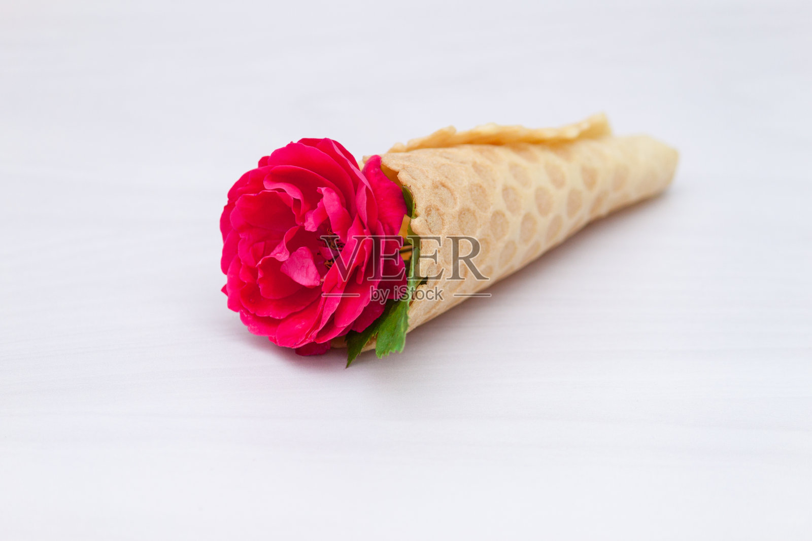 花红色玫瑰在华夫蛋筒在白色木制背景。平躺，俯视图，花卉背景。照片摄影图片