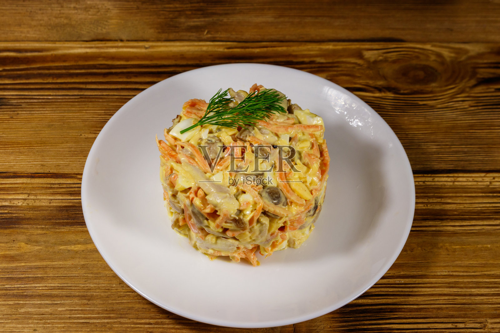 美味的沙拉配鸡胸肉，烤蘑菇，胡萝卜，磨碎的奶酪，鸡蛋和蛋黄酱放在木桌上照片摄影图片