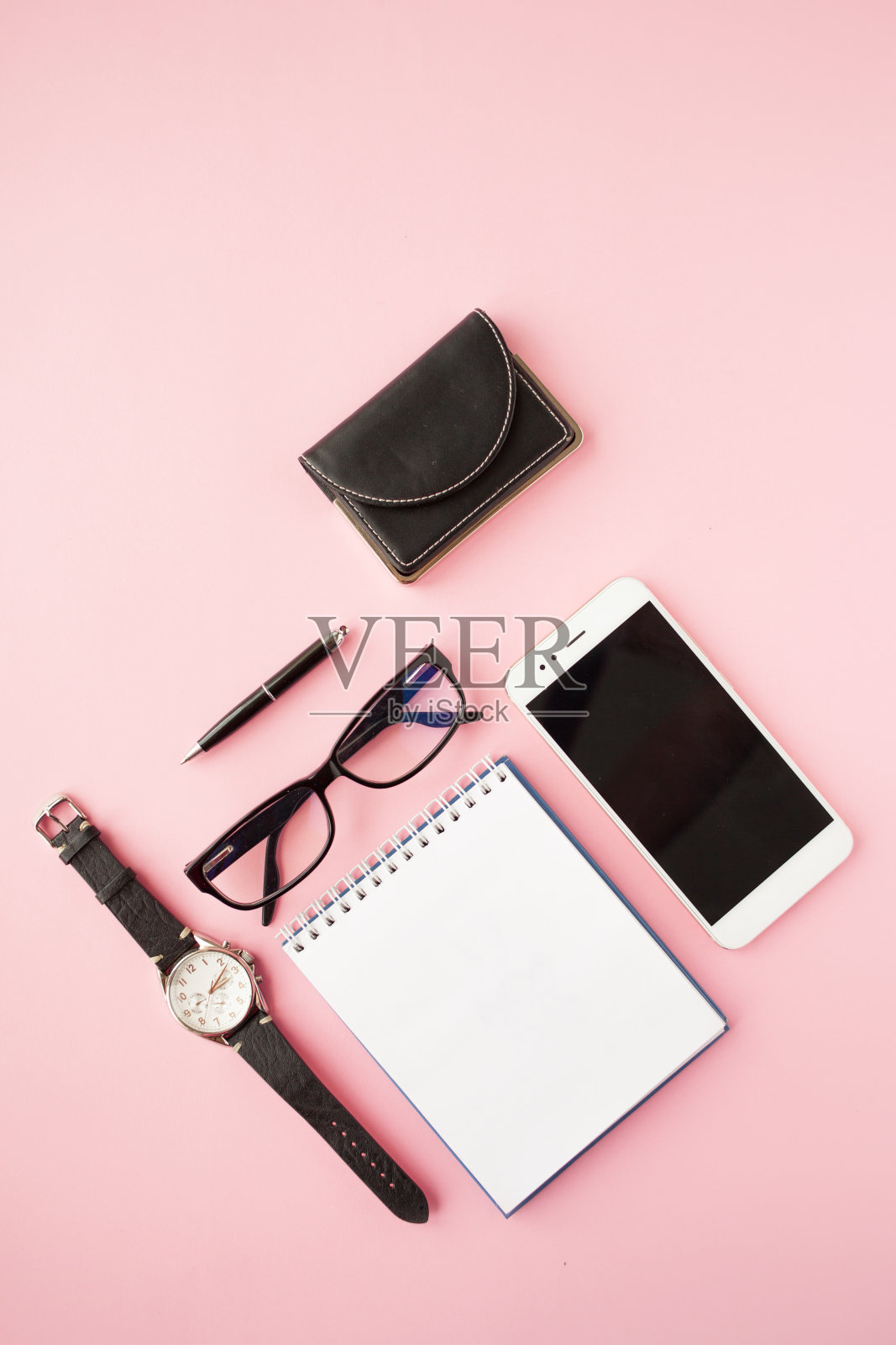 文具，白色智能手机，眼镜，钢笔，钱包，手表，日历，笔记本。粉红色的背景。照片摄影图片