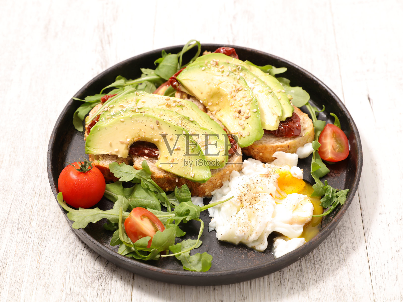 配吐司面包、牛油果、荷包蛋和蔬菜照片摄影图片