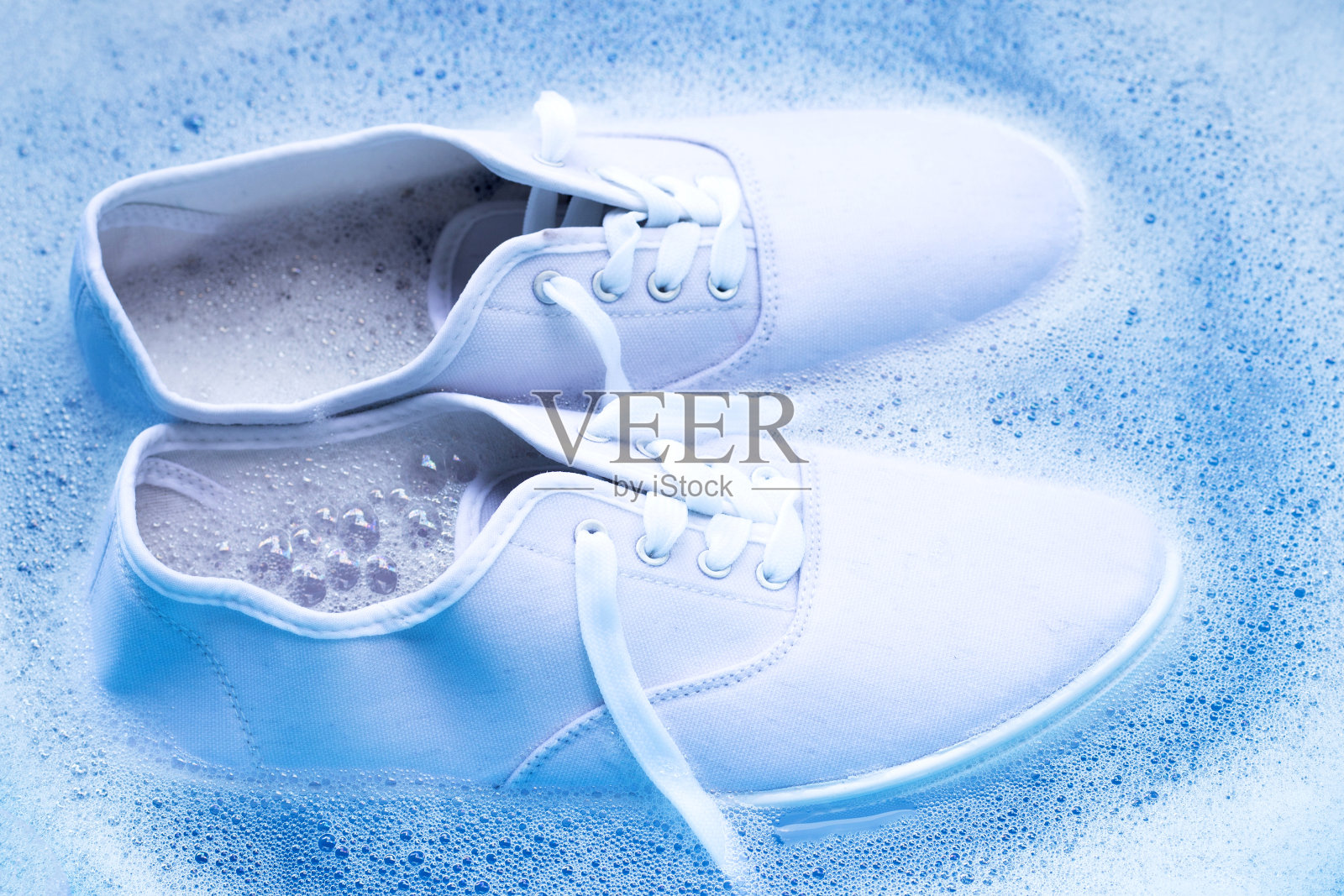 洗鞋前先浸泡。清洗肮脏的运动鞋。照片摄影图片