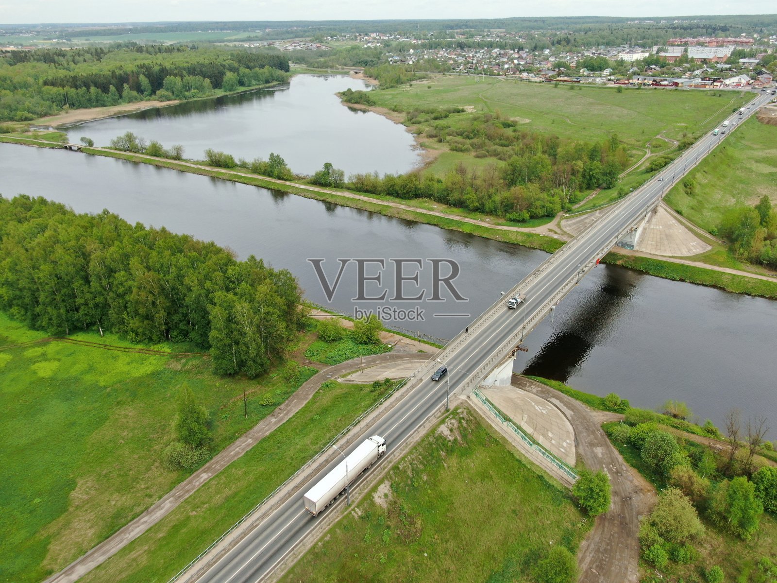 从桥的高度俯瞰河上美丽的全景景观。货轮在河上行驶的桥上的车辆交通。无人机上的照片照片摄影图片