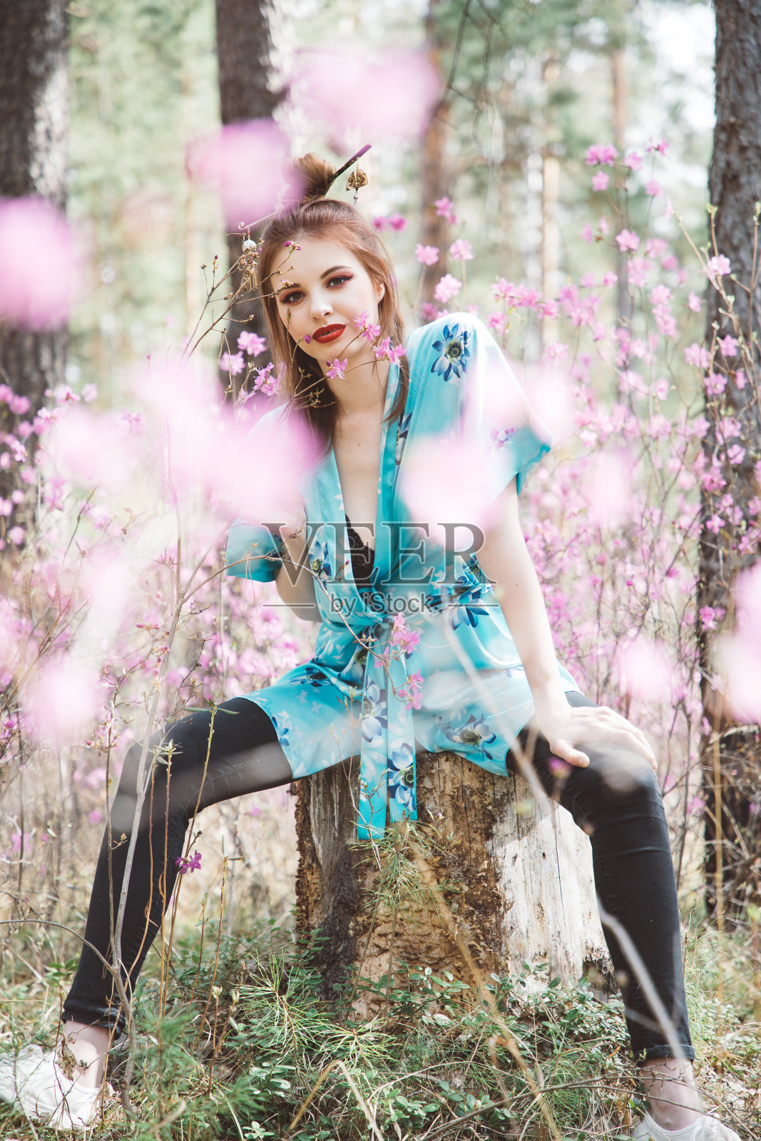 春天，一个日本女孩在粉红色的花丛中照片摄影图片