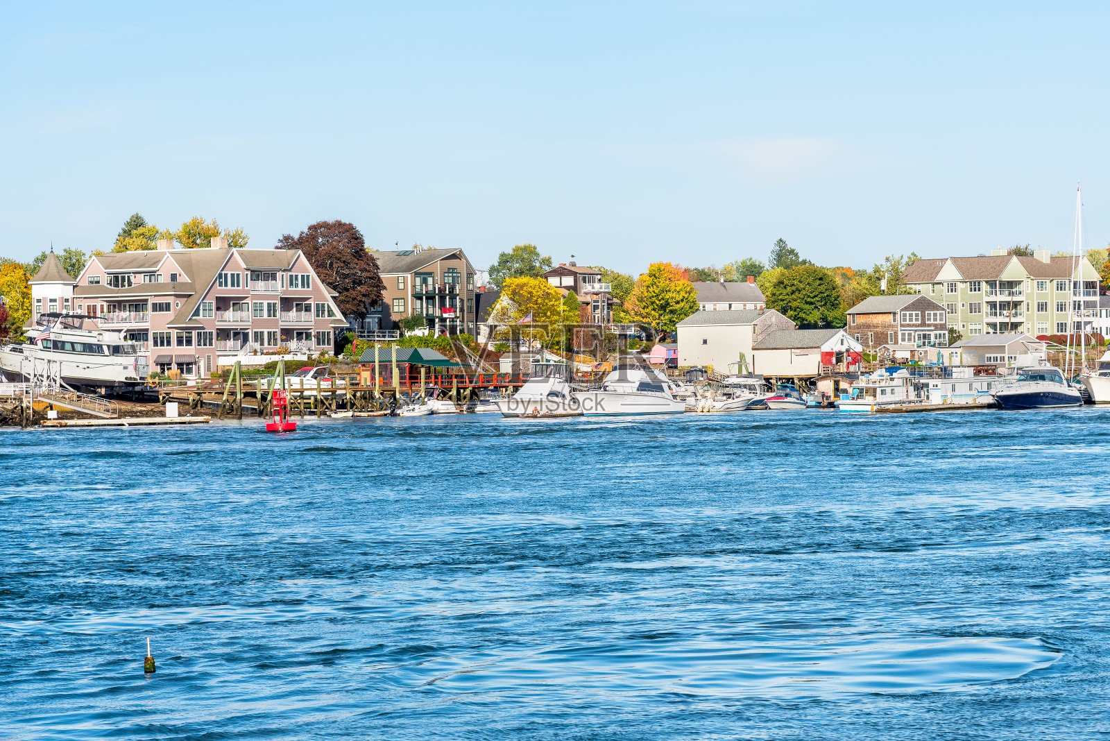 游艇停泊在河港，背景是住宅楼照片摄影图片