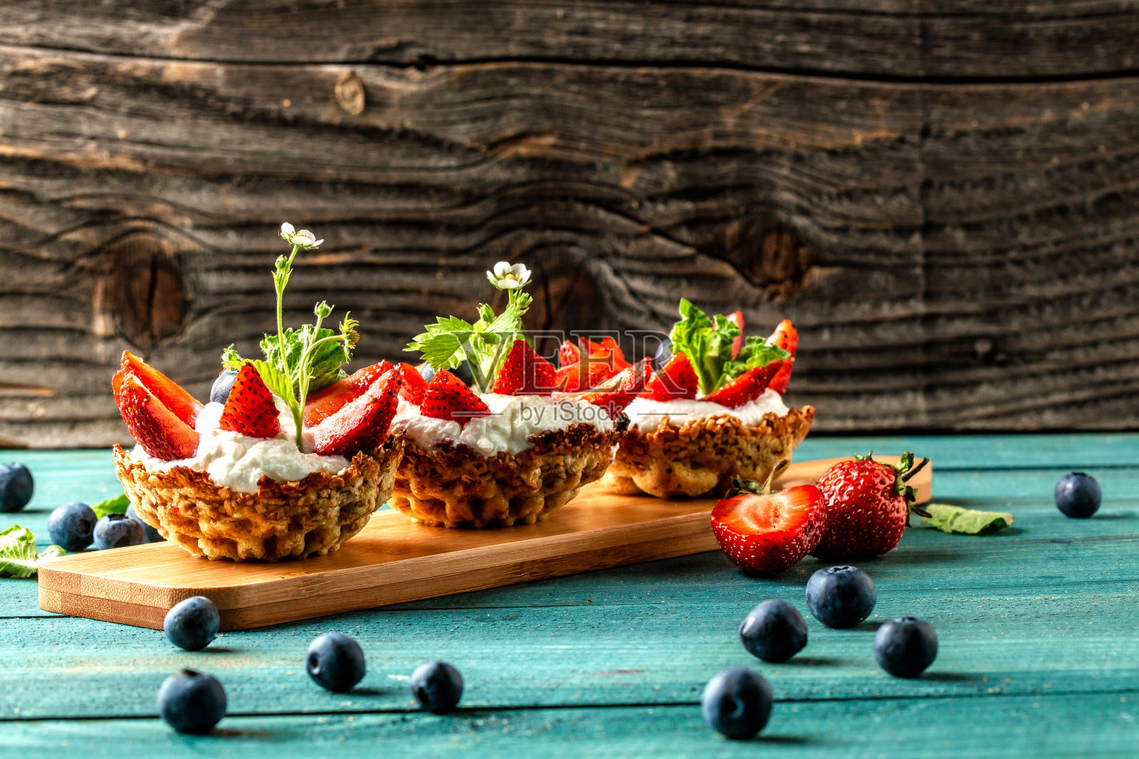 奶油、草莓和蓝莓果馅饼放在木桌上。横幅菜单食谱的文本位置照片摄影图片