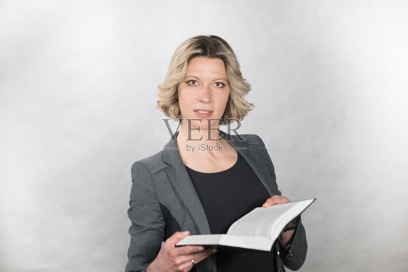 女商人手里拿着一本书。照片摄影图片