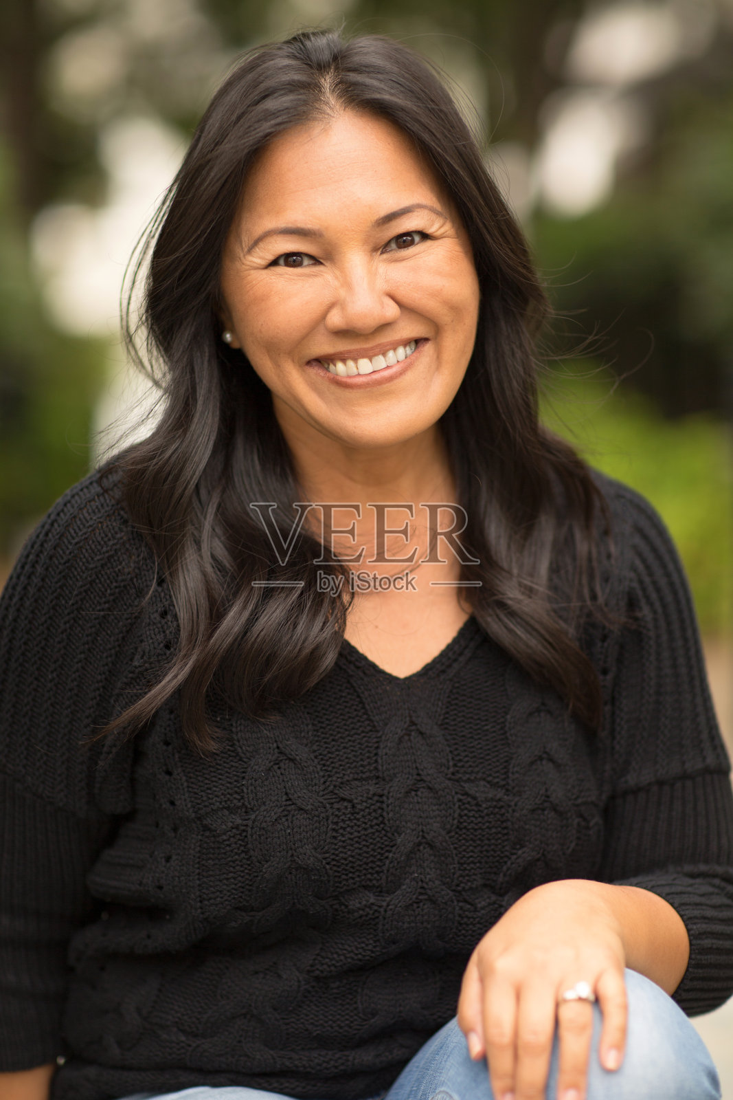 一个坐在外面的亚洲女人的肖像。照片摄影图片