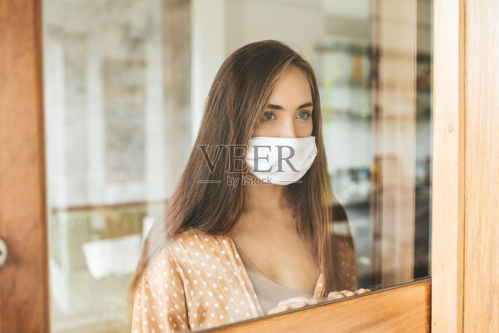 戴医用口罩的年轻女子留在家中进行自我隔离。照片摄影图片