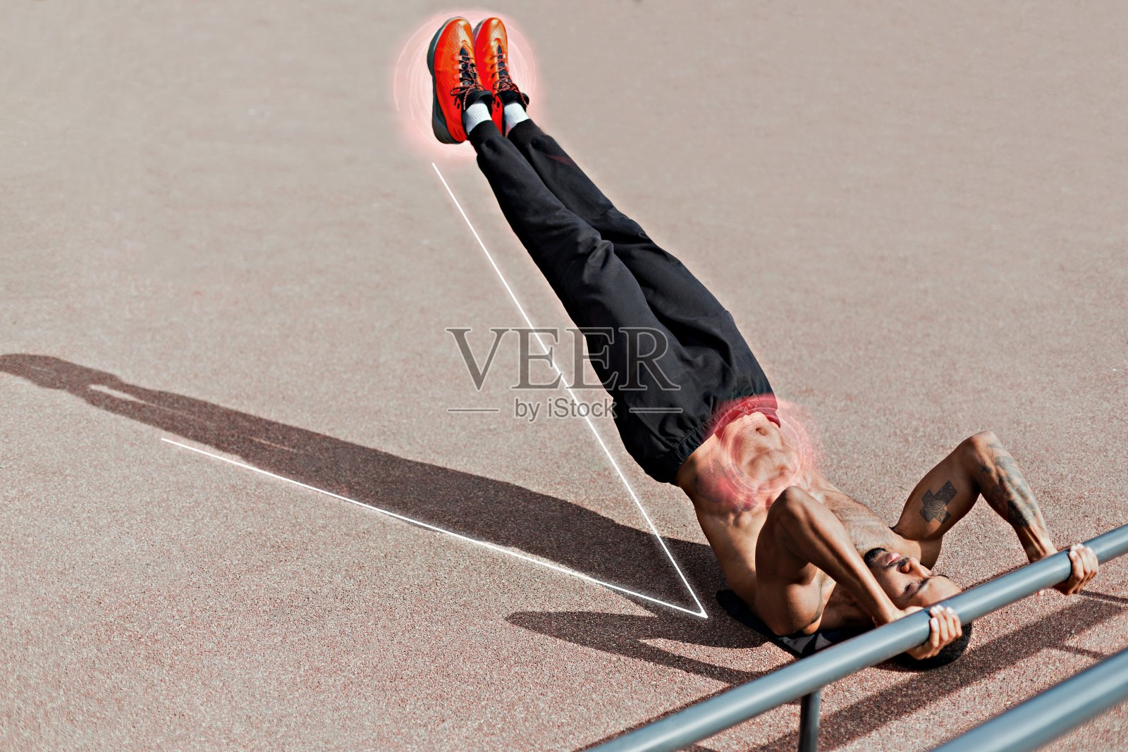 户外腹肌练习。赤裸上身的肌肉男在操场上做腹部训练，拼贴着空的空间照片摄影图片