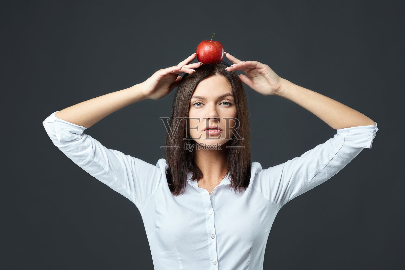 漂亮的女孩，灰色背景下有一个红苹果照片摄影图片