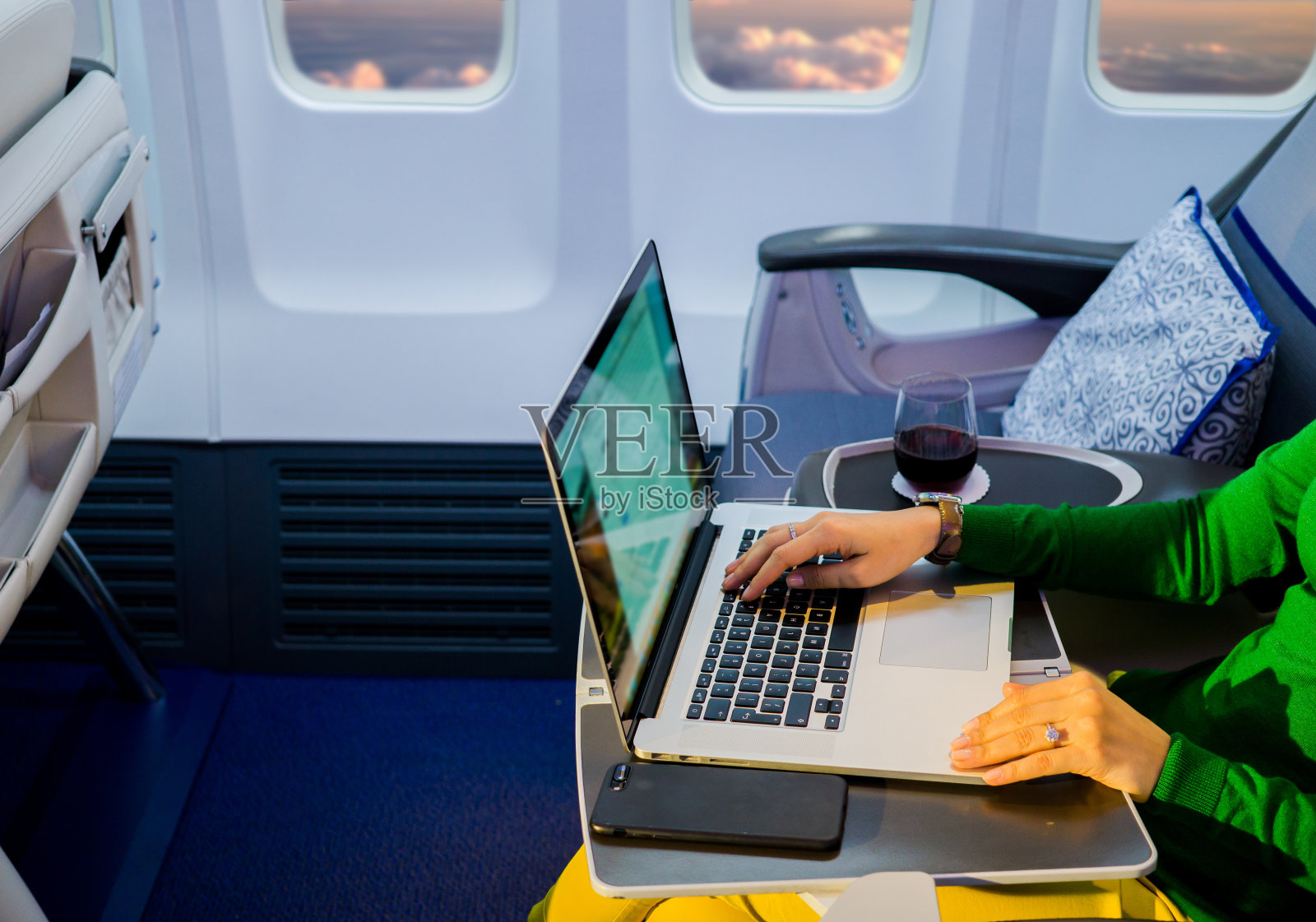 近距离的女人手工作的笔记本电脑在飞机桌上照片摄影图片