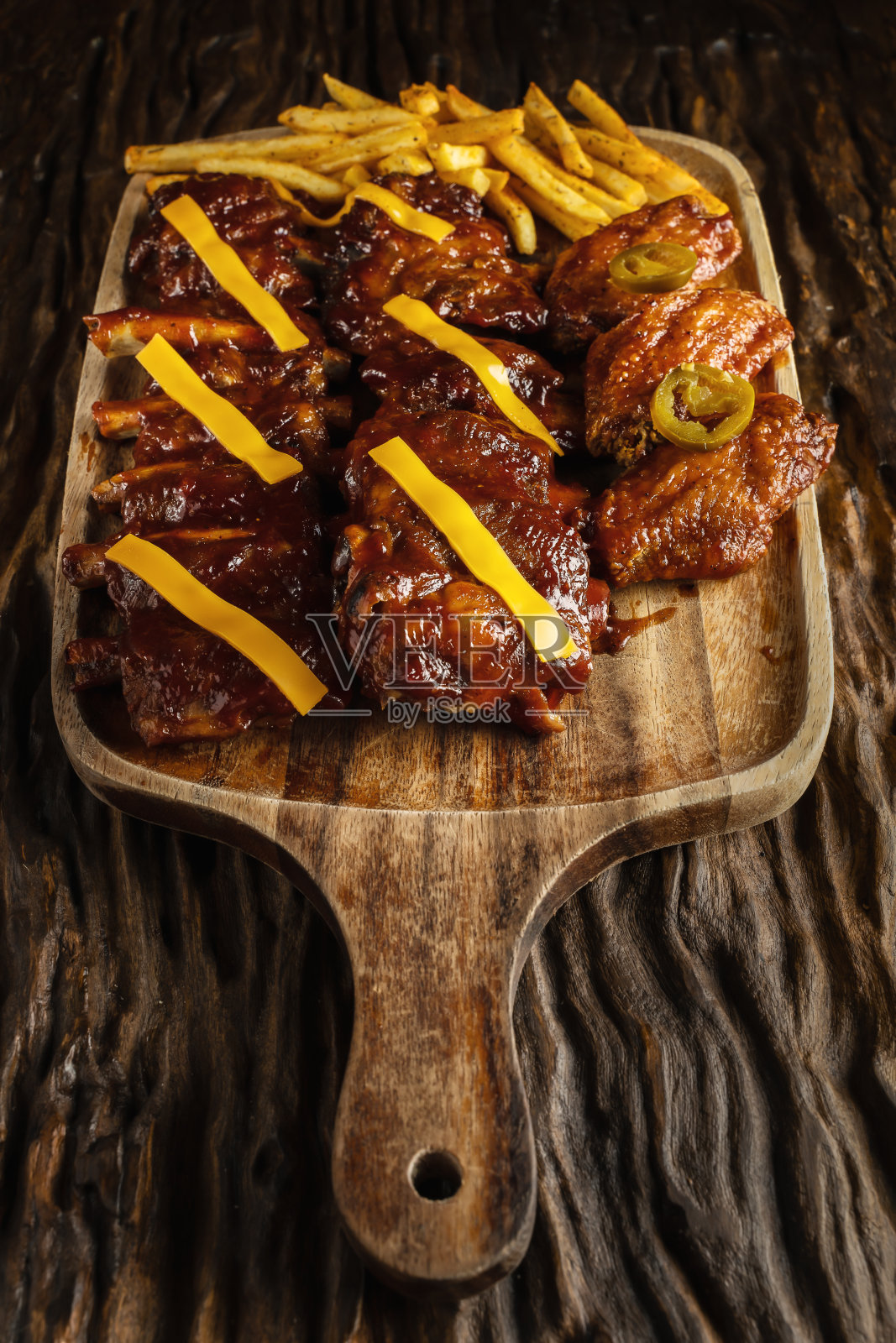 以美式食物为背景，以烧烤排骨、鸡翅、法式油炸和芝士为搭配，以深色为基调照片摄影图片