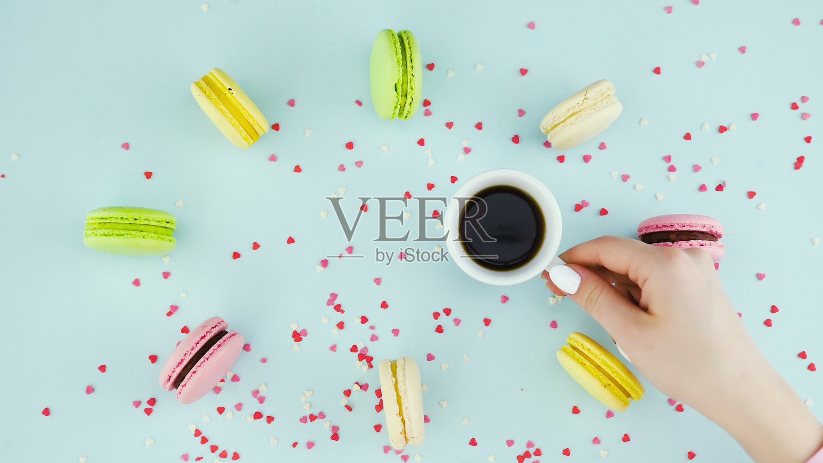 马卡龙或粉蓝色表面的马卡龙，加浓咖啡在白色杯子里。照片摄影图片