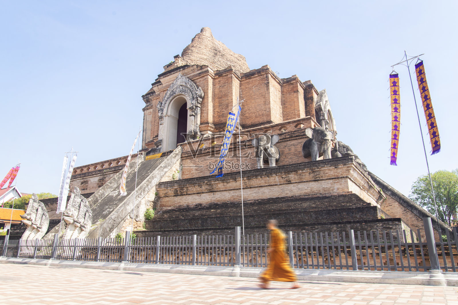 一位佛教僧人正走过清迈的古老寺庙废墟。照片摄影图片
