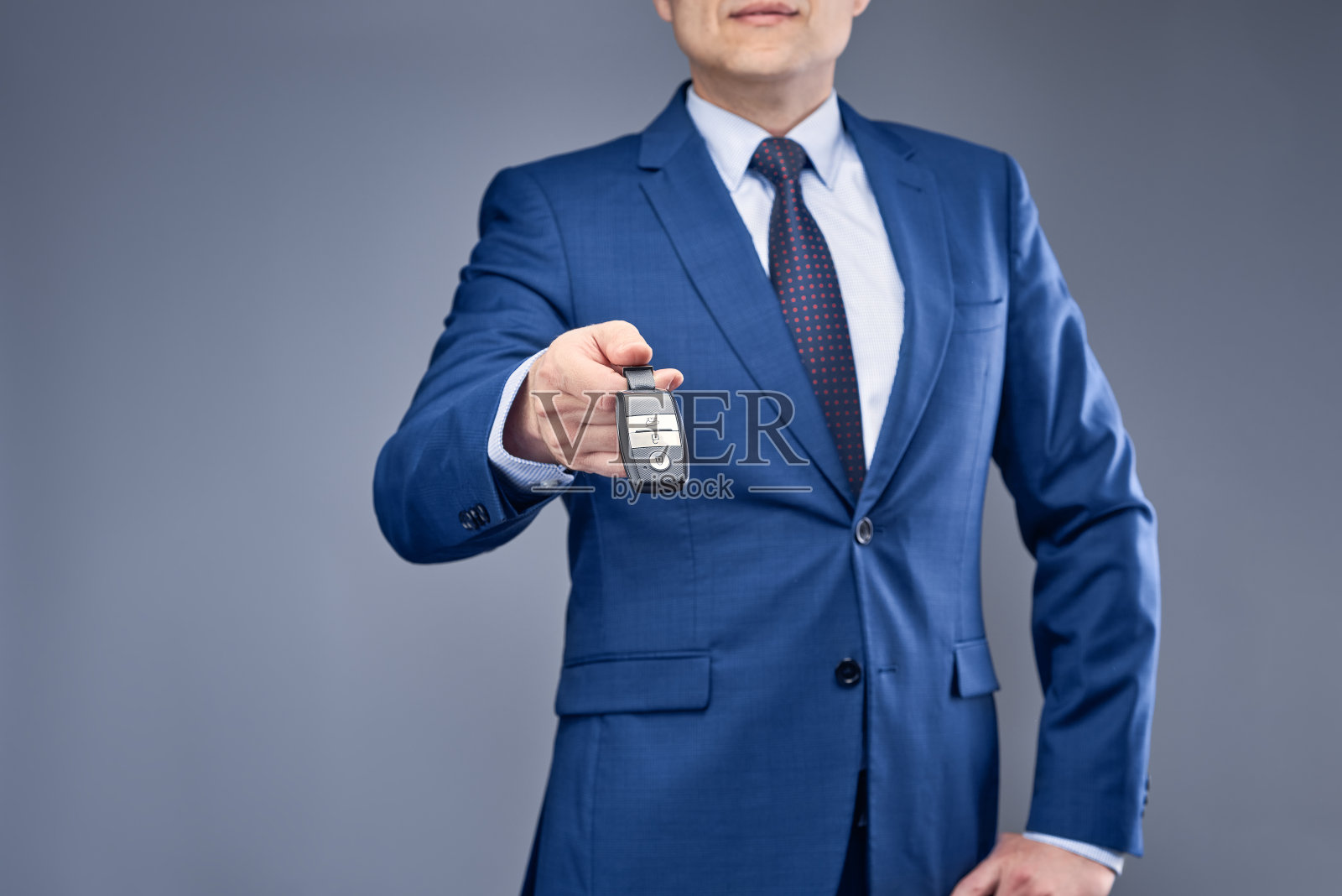 穿着蓝色西装，灰蓝色背景的商人照片摄影图片