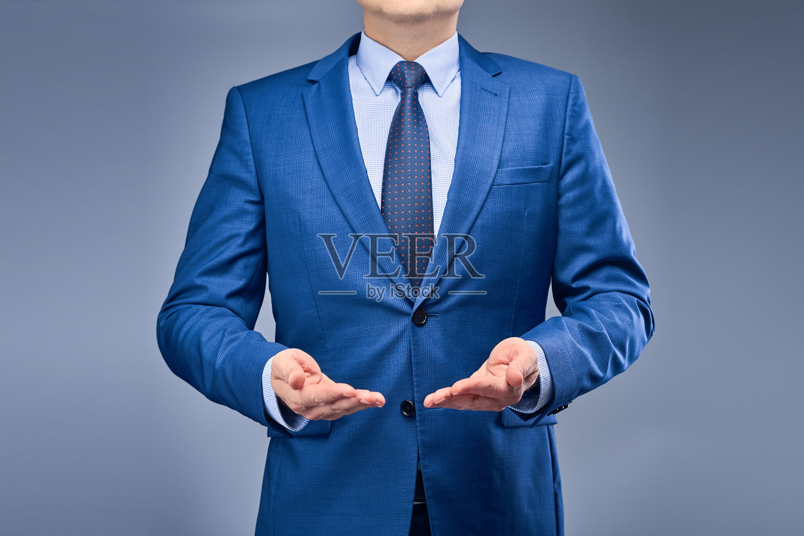 穿着蓝色西装，灰蓝色背景的商人照片摄影图片