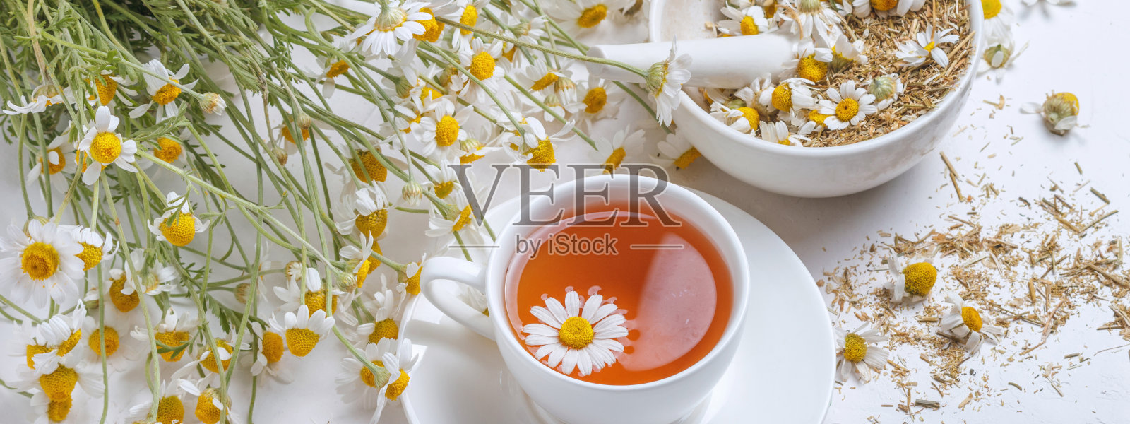 乡村静物——一杯泡好的甘菊茶，背景是一束雏菊照片摄影图片