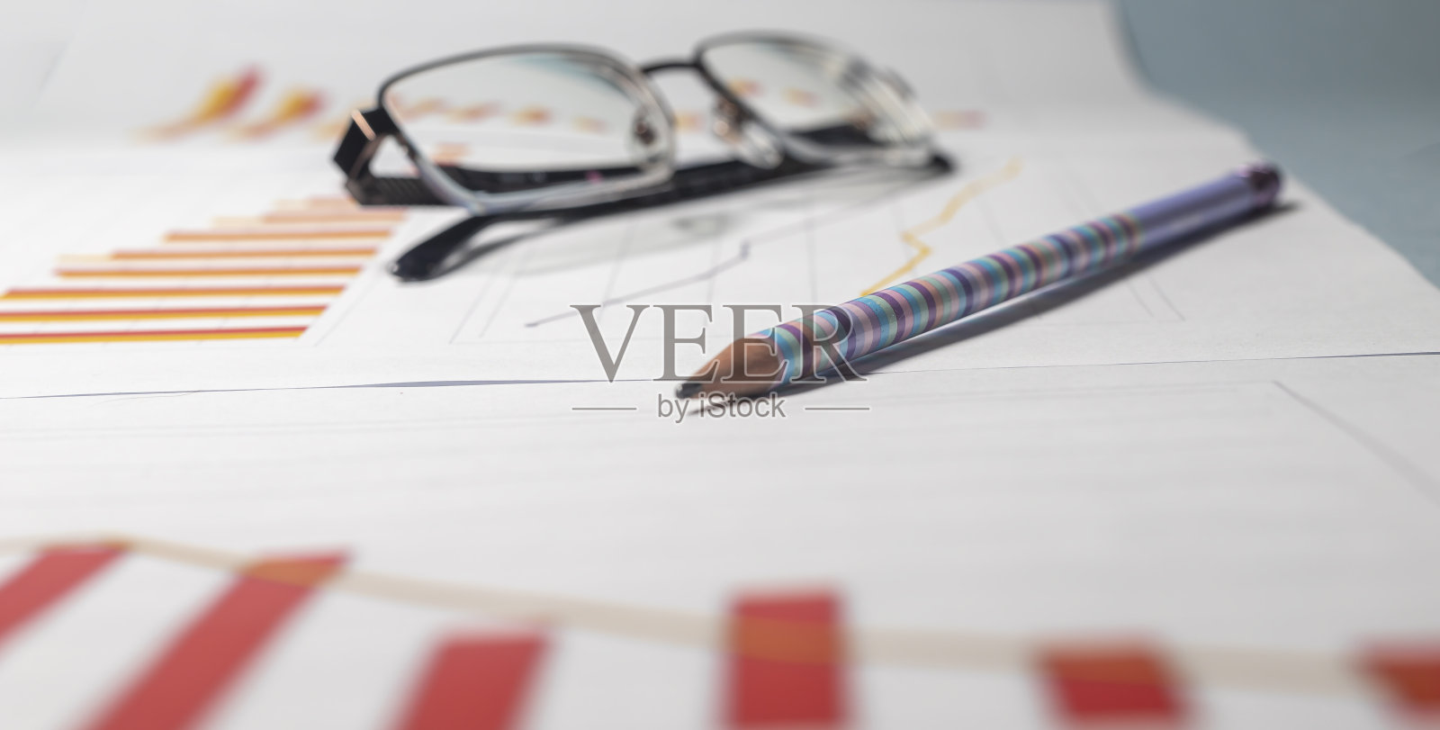 铅笔眼镜和业务图表图表与下降趋势在红色和橙色。企业危机分析概念照片摄影图片