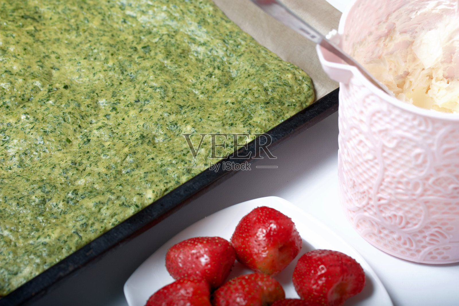 做蛋糕用的生面团。用于制作菠菜、薄荷饼干卷。塞满了草莓。原料烹饪。照片摄影图片