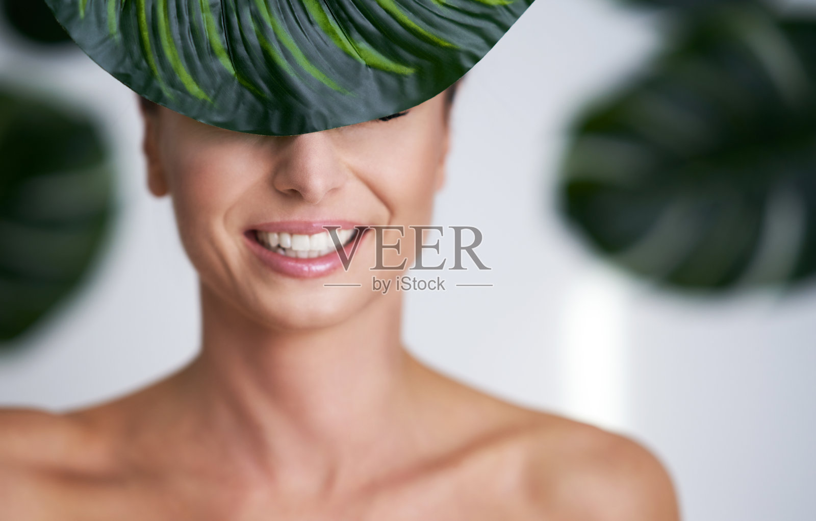 美丽的成年女子在树叶的背景下摆姿势照片摄影图片