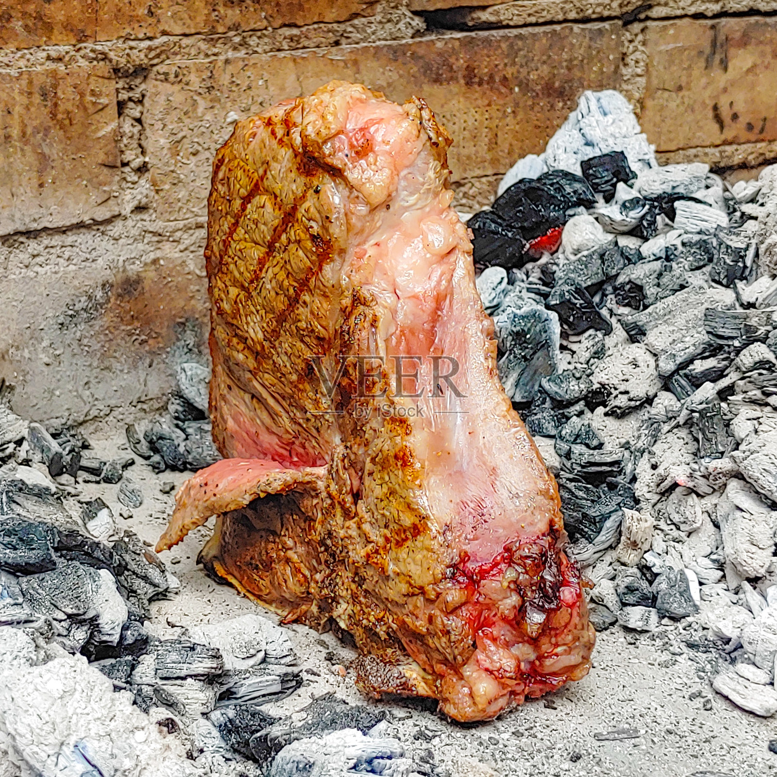 用炭炉煮的带骨牛排照片摄影图片