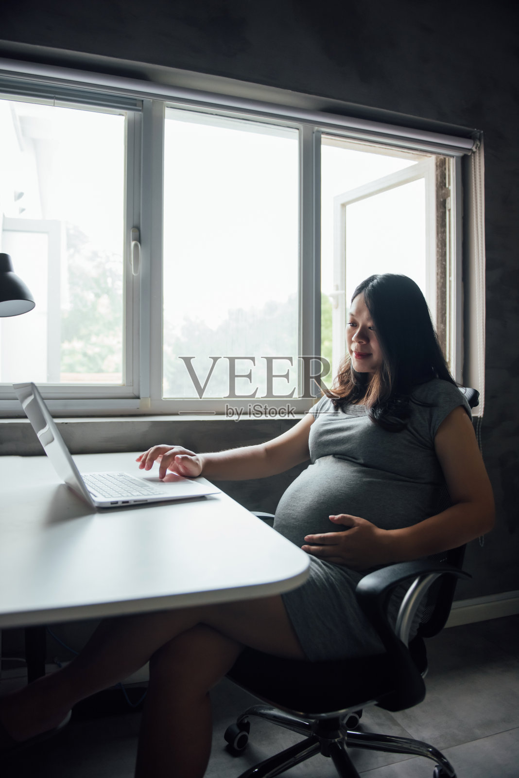 一名亚裔孕妇正在工作照片摄影图片