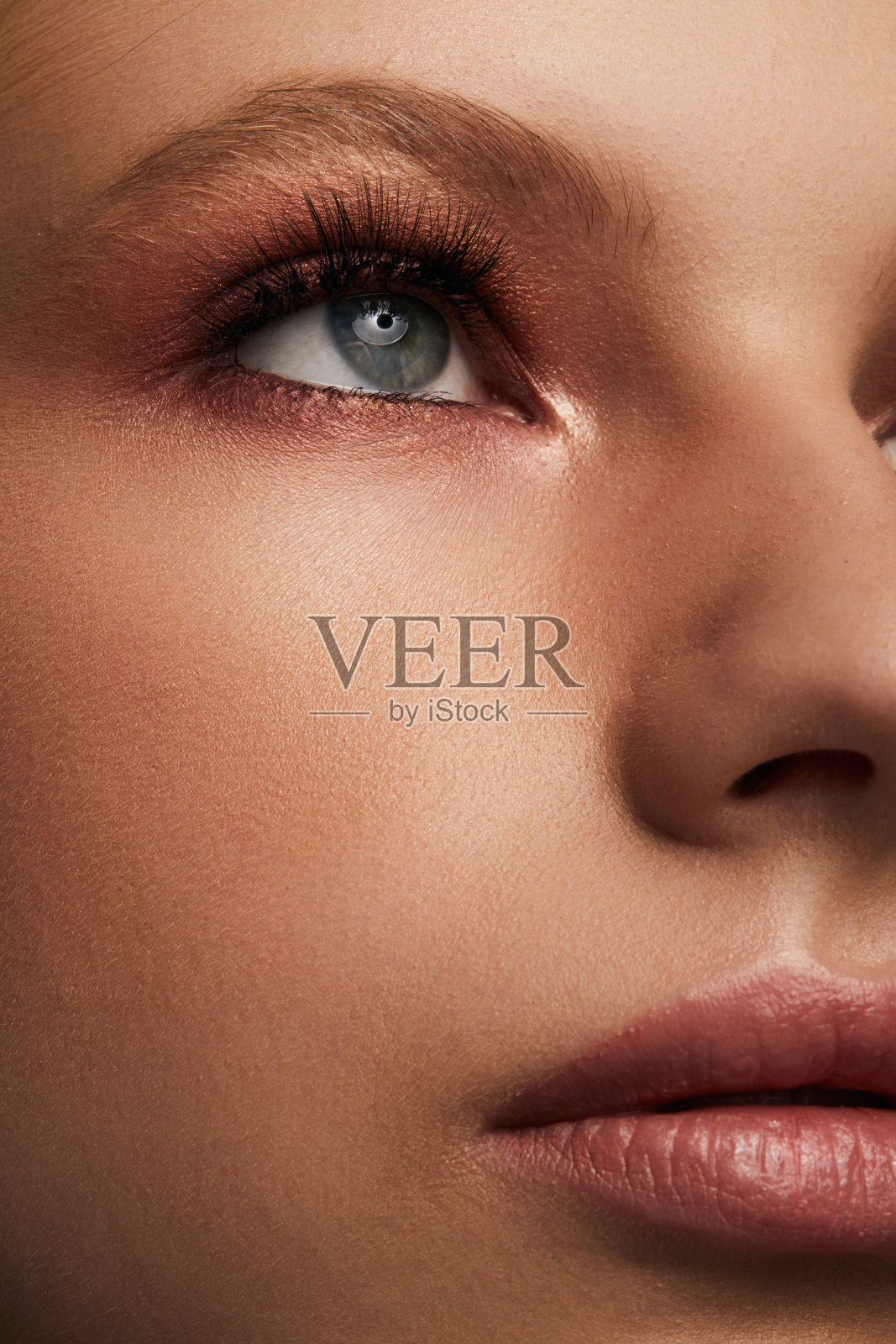 美丽的年轻女子的脸与干净新鲜的皮肤近距离隔离在灰色的背景。美丽的肖像。完美的新皮肤。纯美的模型。青春护肤理念照片摄影图片