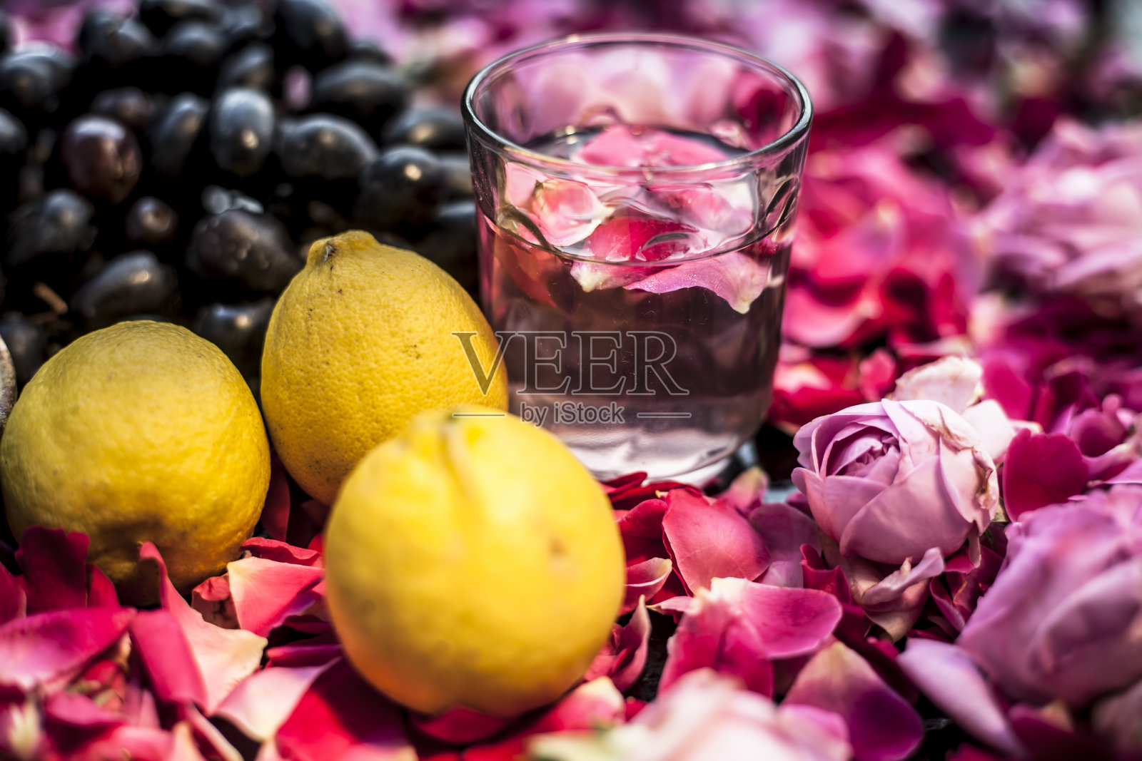 在黑板上用一些葡萄浆和柠檬汁混合均匀的方法敷面膜或解决皮肤过油的方法。少量的葡萄柚，一些红色和粉色的玫瑰和柠檬。照片摄影图片