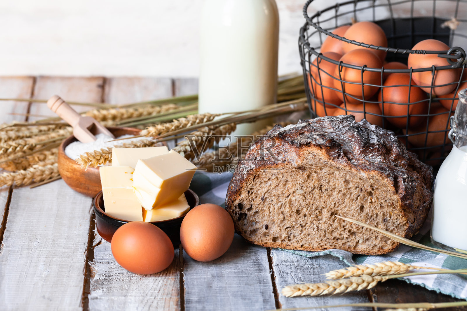 概念自制面包，天然农产品，国内生产。健康美味的有机食品。鸡蛋、黄油、面包、牛奶、面粉。用小麦做装饰。特写镜头,木制背景照片摄影图片
