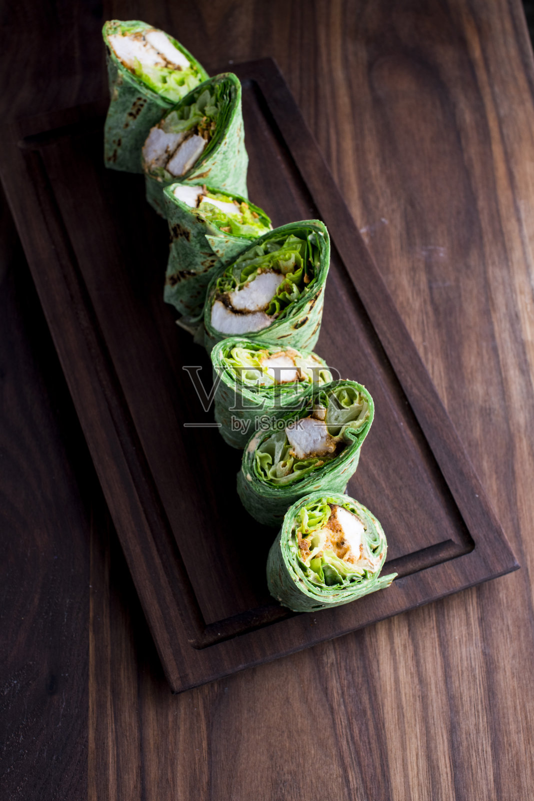 鸡包三明治。鸡肉沙拉，由烤鸡胸肉，芹菜，胡萝卜，蔓越莓，长叶莴苣和蛋黄酱卷在有机蔬菜玉米饼。照片摄影图片