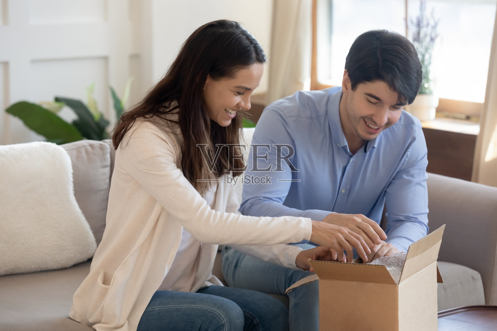快乐的年轻夫妇打开纸板箱与网上订购照片摄影图片