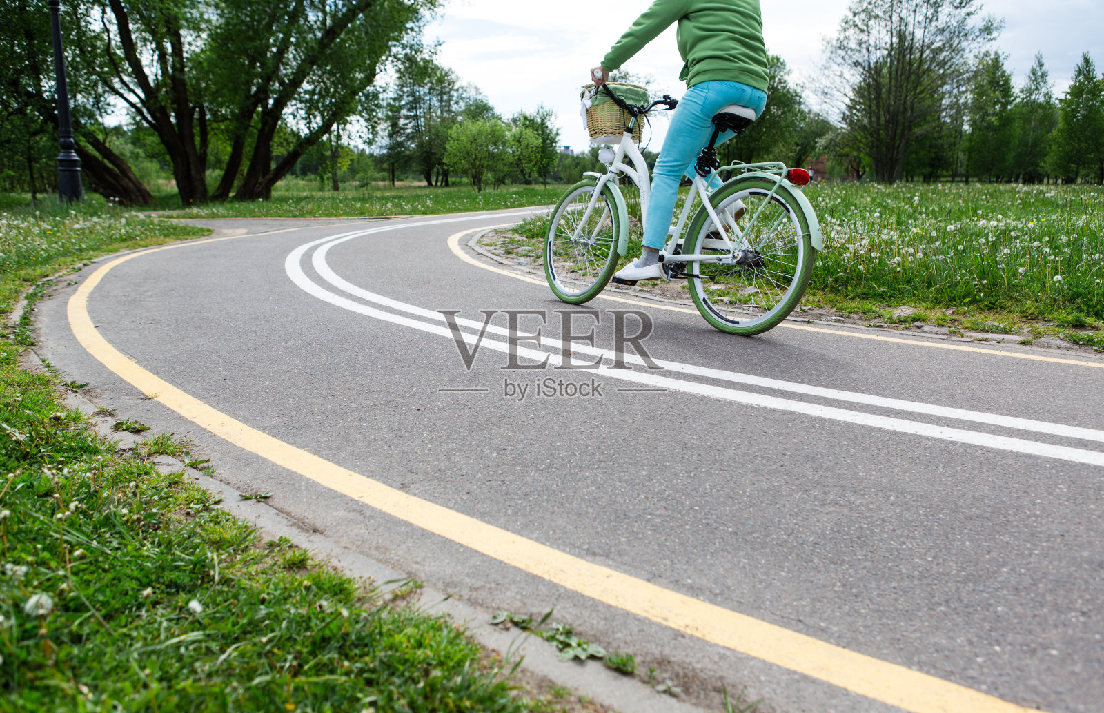 在公园有标记的自行车道上骑自行车的女人照片摄影图片