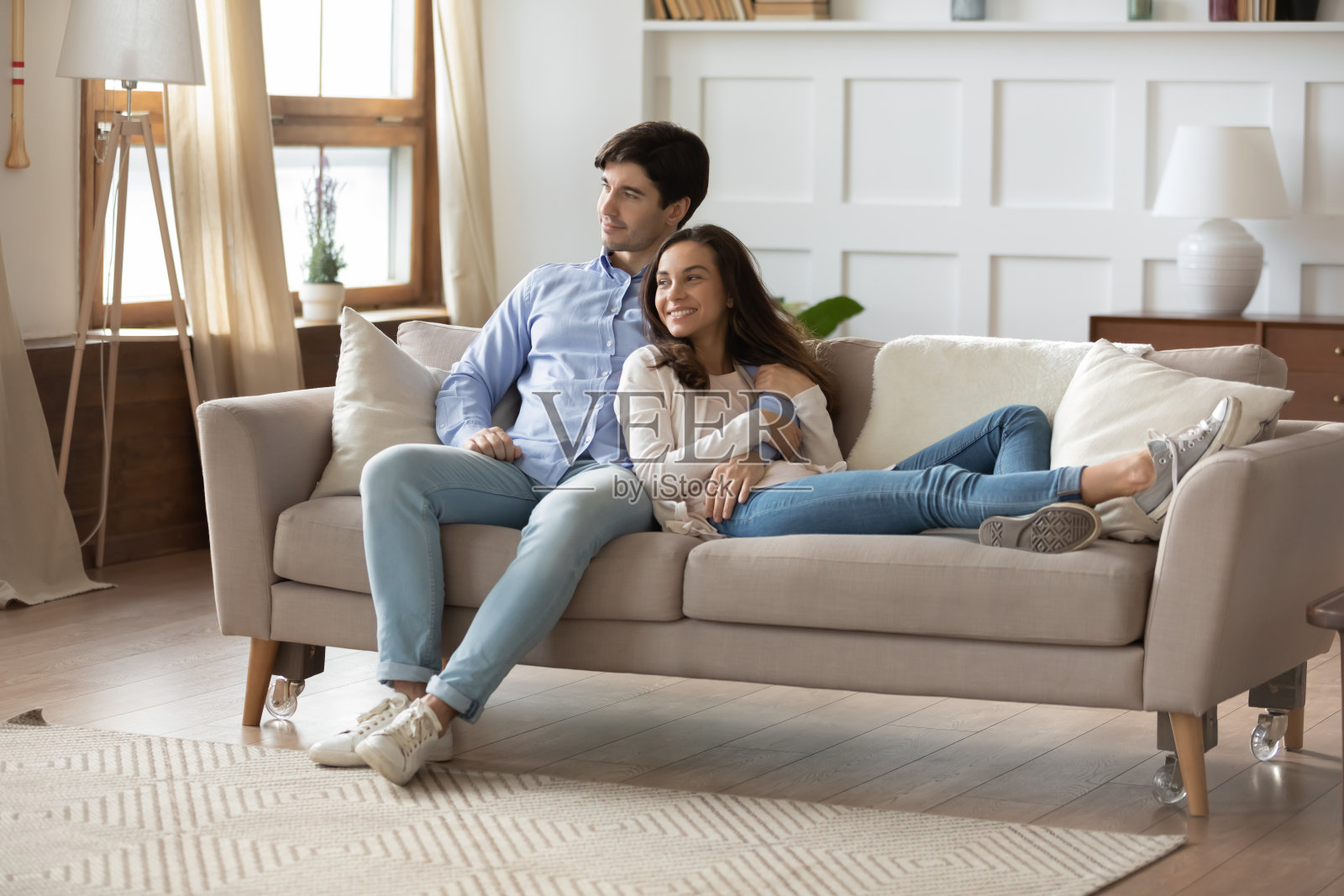 幸福的年轻夫妇在新公寓的沙发上休息照片摄影图片