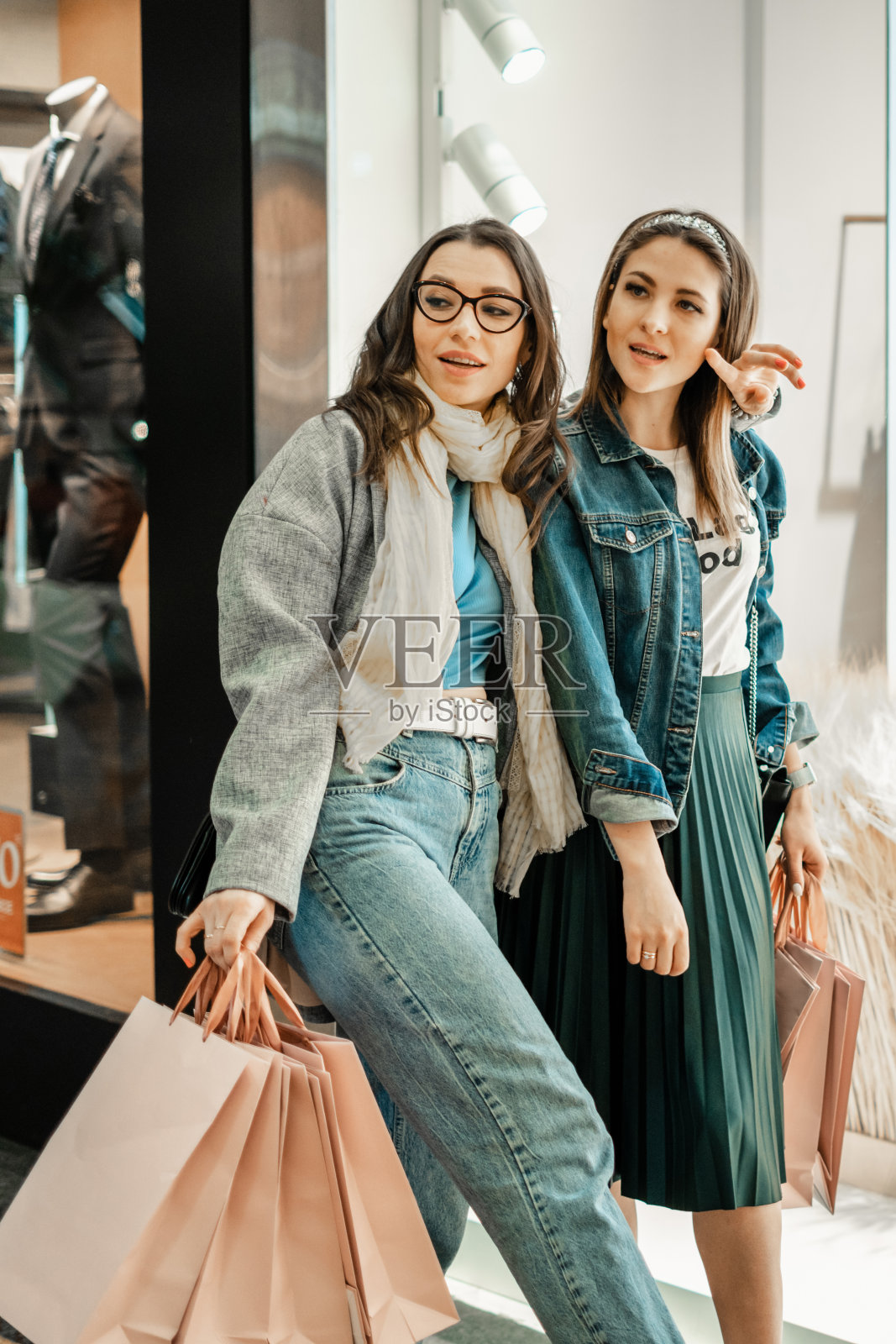 交易,买家。两个漂亮的女孩在购物中心购物。消费的乐趣。照片摄影图片