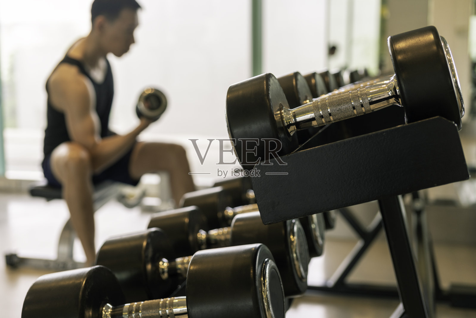 近距离的哑铃机架与亚洲人做锻炼背后照片摄影图片