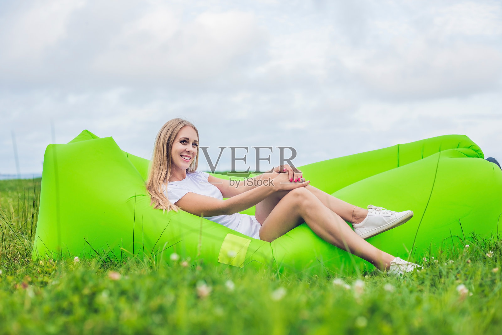 一个年轻女子在公园的空中沙发上休息。照片摄影图片