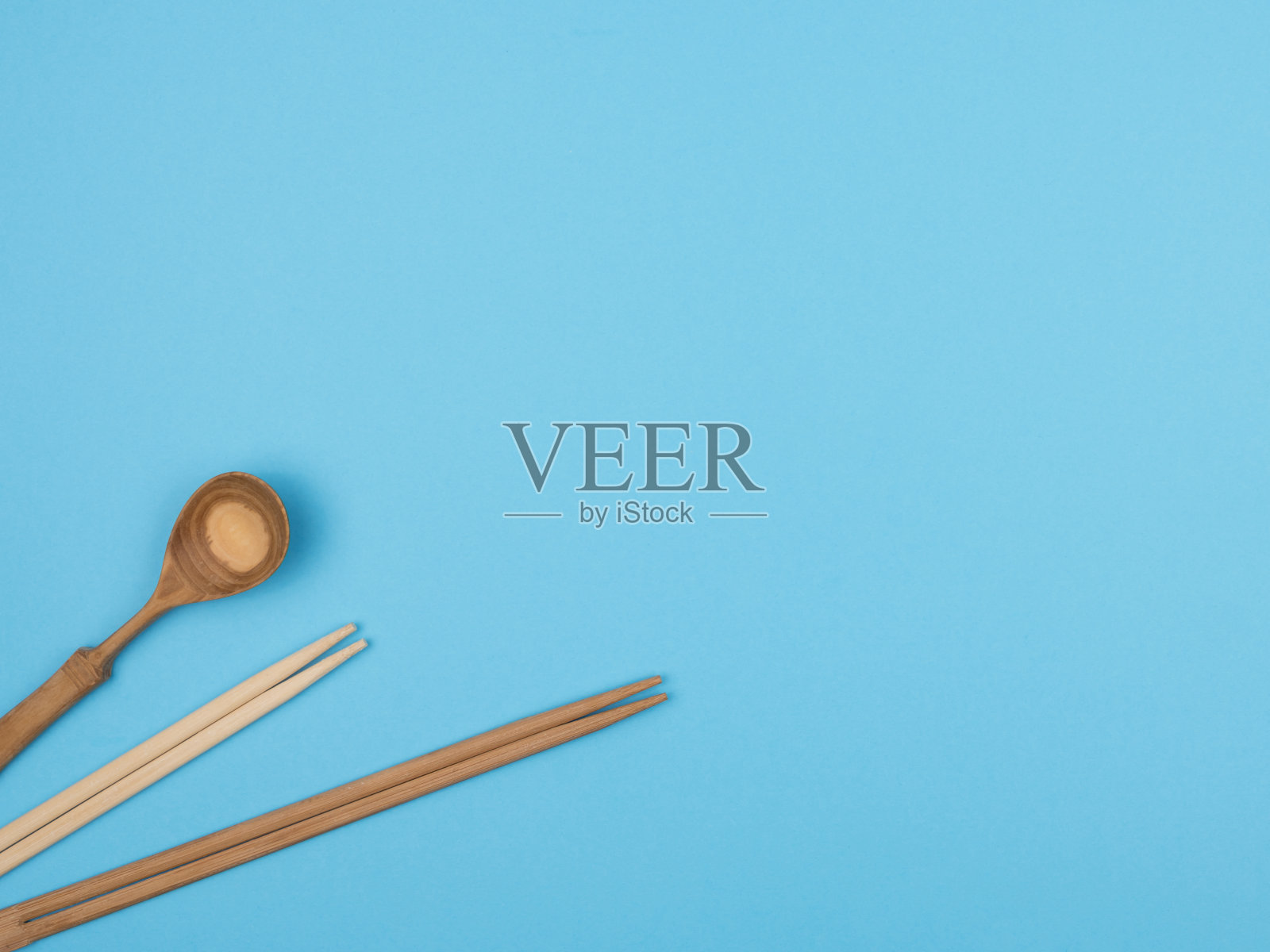 蓝色背景上的寿司木棒和勺子。照片摄影图片