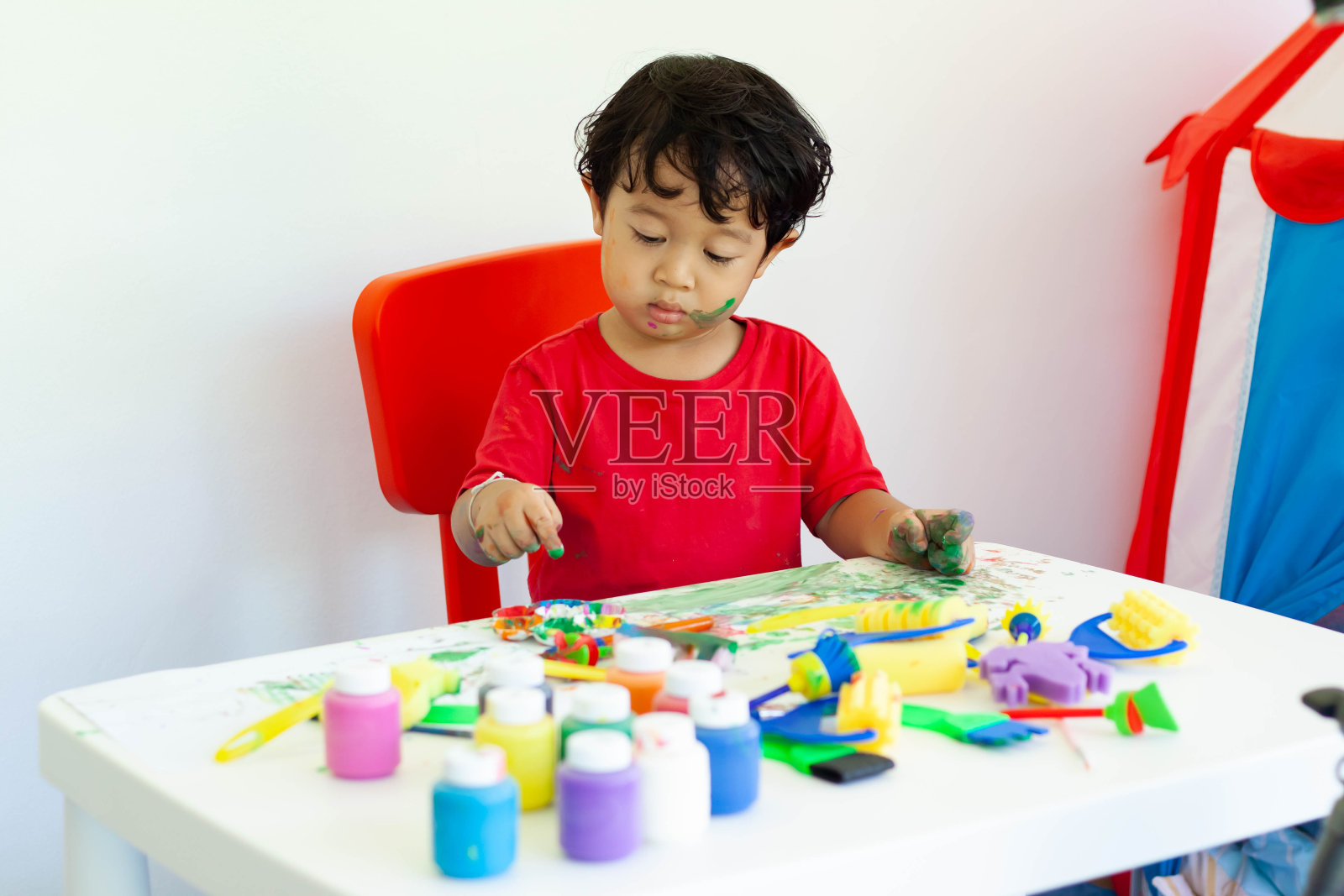 孩子们呆在家里玩水彩画。小男孩和水彩画。照片摄影图片