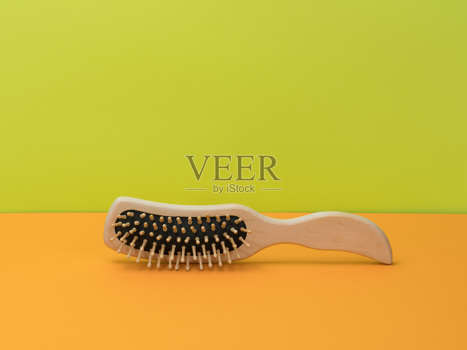 木梳在明亮的橙色和绿色背景上。照片摄影图片