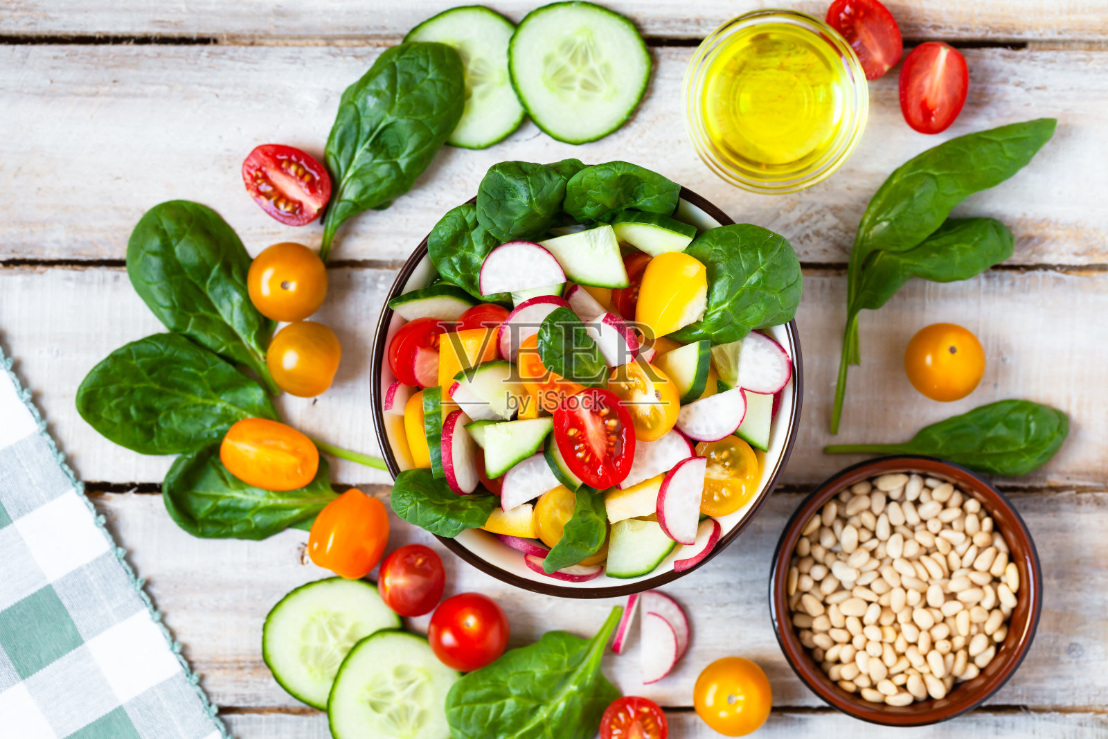 健康食品、清洁饮食、节食的观念。五颜六色的新鲜蔬菜沙拉在一个碗。简单的烹饪，完美的夏季便餐。木制背景平铺俯视图照片摄影图片
