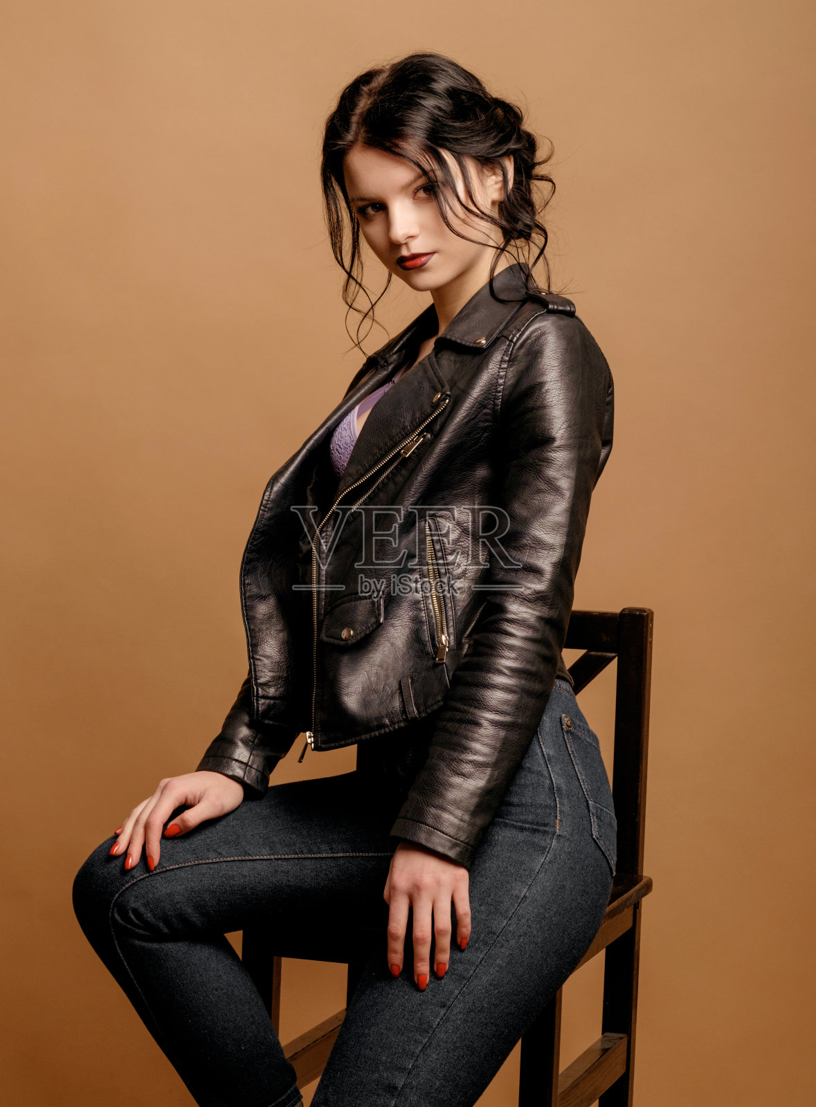 美丽的肖像上的一个年轻女子米色背景，皮肤护理，黑色夹克照片摄影图片