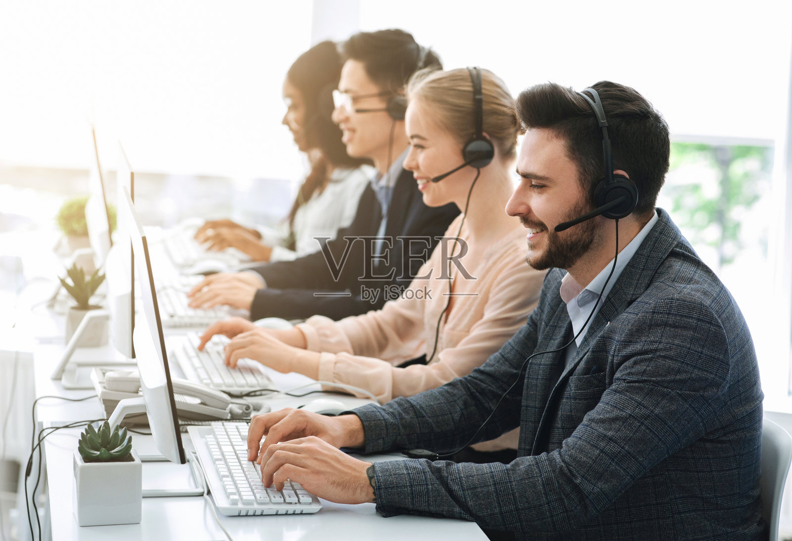 电话销售或热线接线员在办公室使用电脑工作照片摄影图片