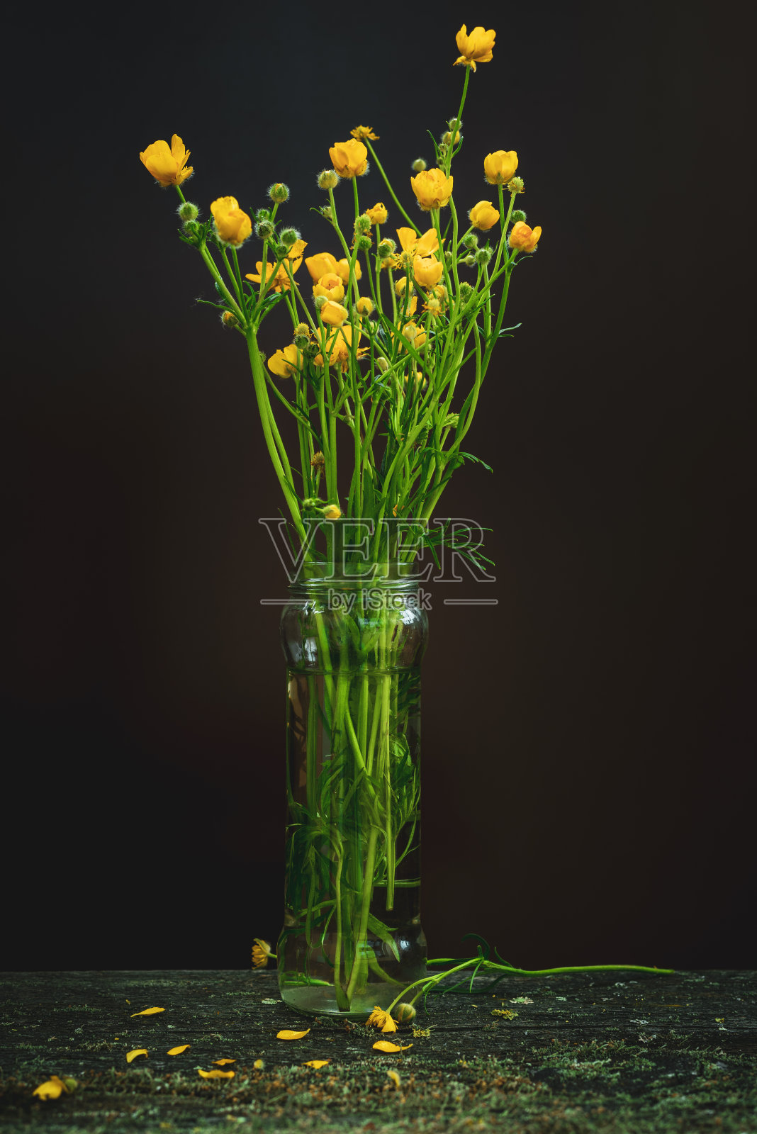 木桌玻璃罐里放着黄色的野花照片摄影图片