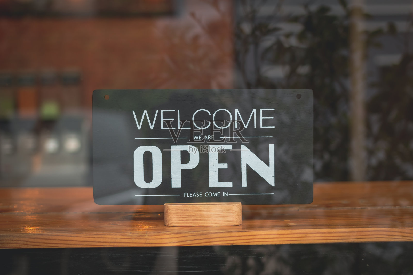 咖啡馆和餐厅的黑色招牌上写着“请进，我们开门了”。照片摄影图片