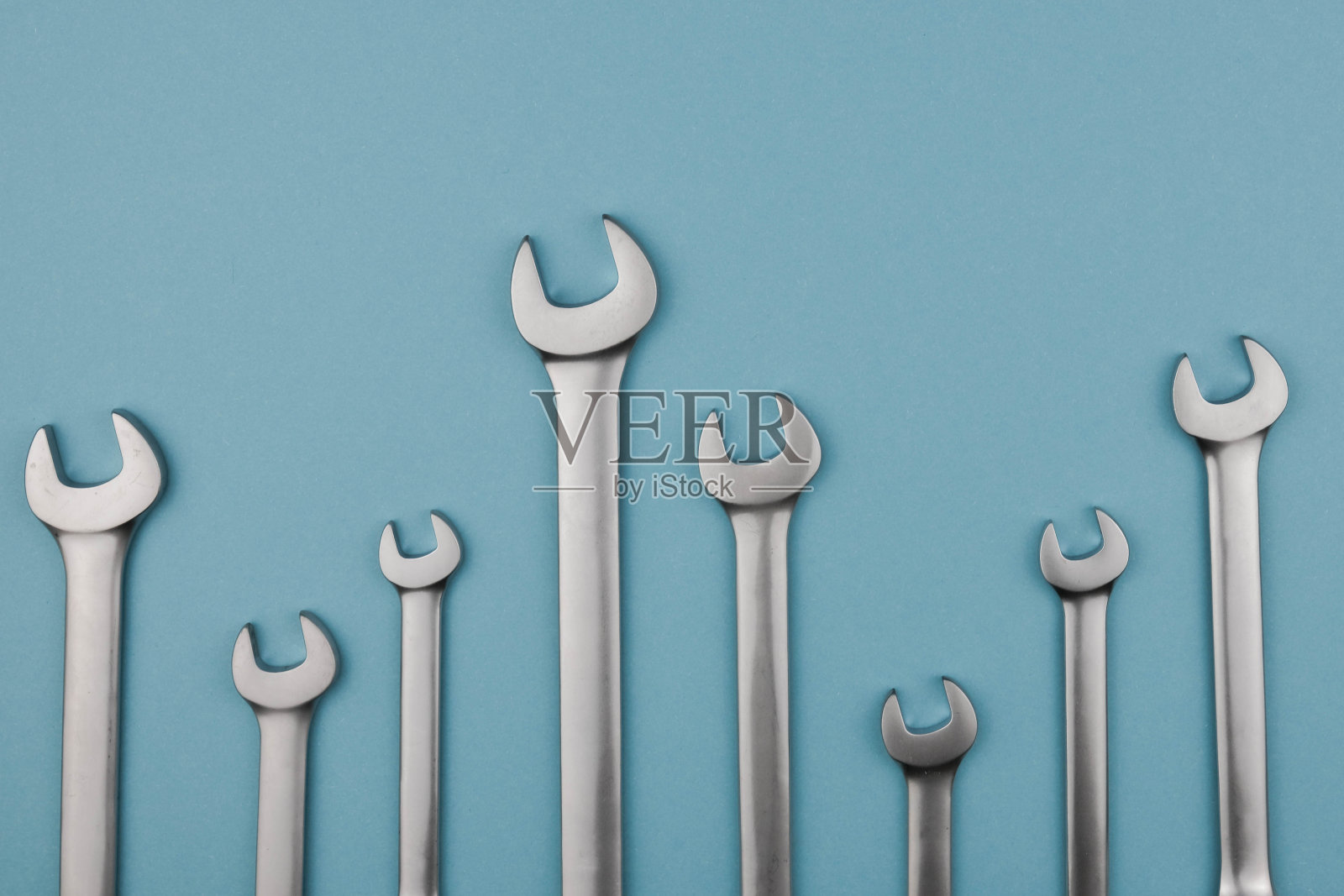 设置铬扳手键并排躺在蓝色背景上。平躺，俯视图，最小的组成照片摄影图片