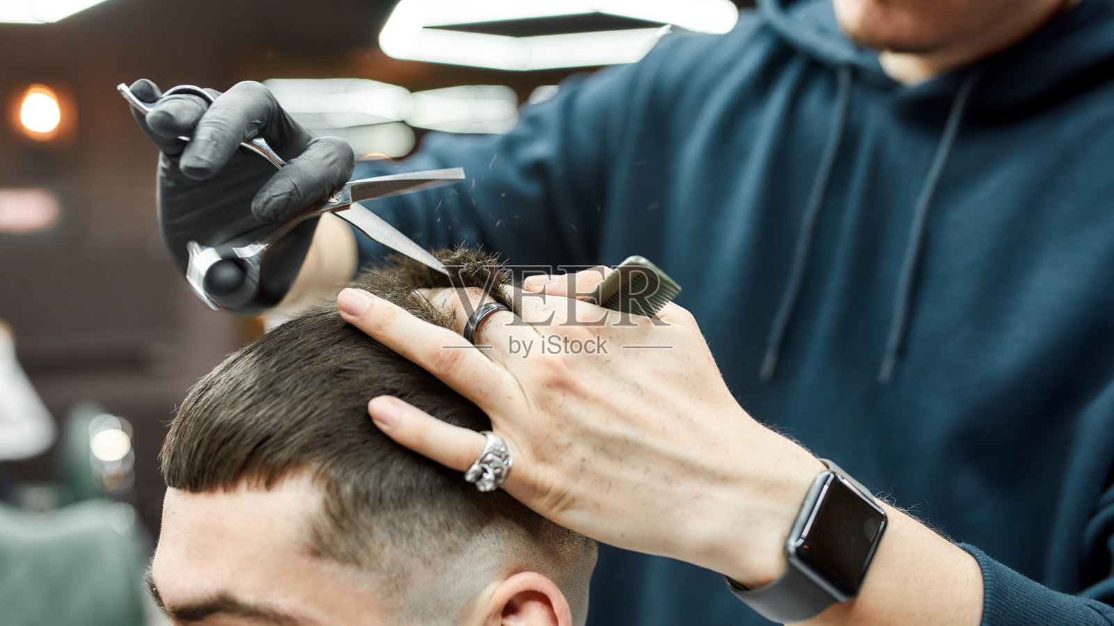 男人理发。剪短的照片，理发师拿着剪刀和梳子，在理发店工作时理发照片摄影图片