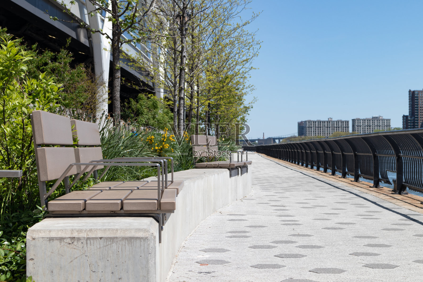 纽约市上东区，空荡荡的长凳和沿着东河的小径照片摄影图片