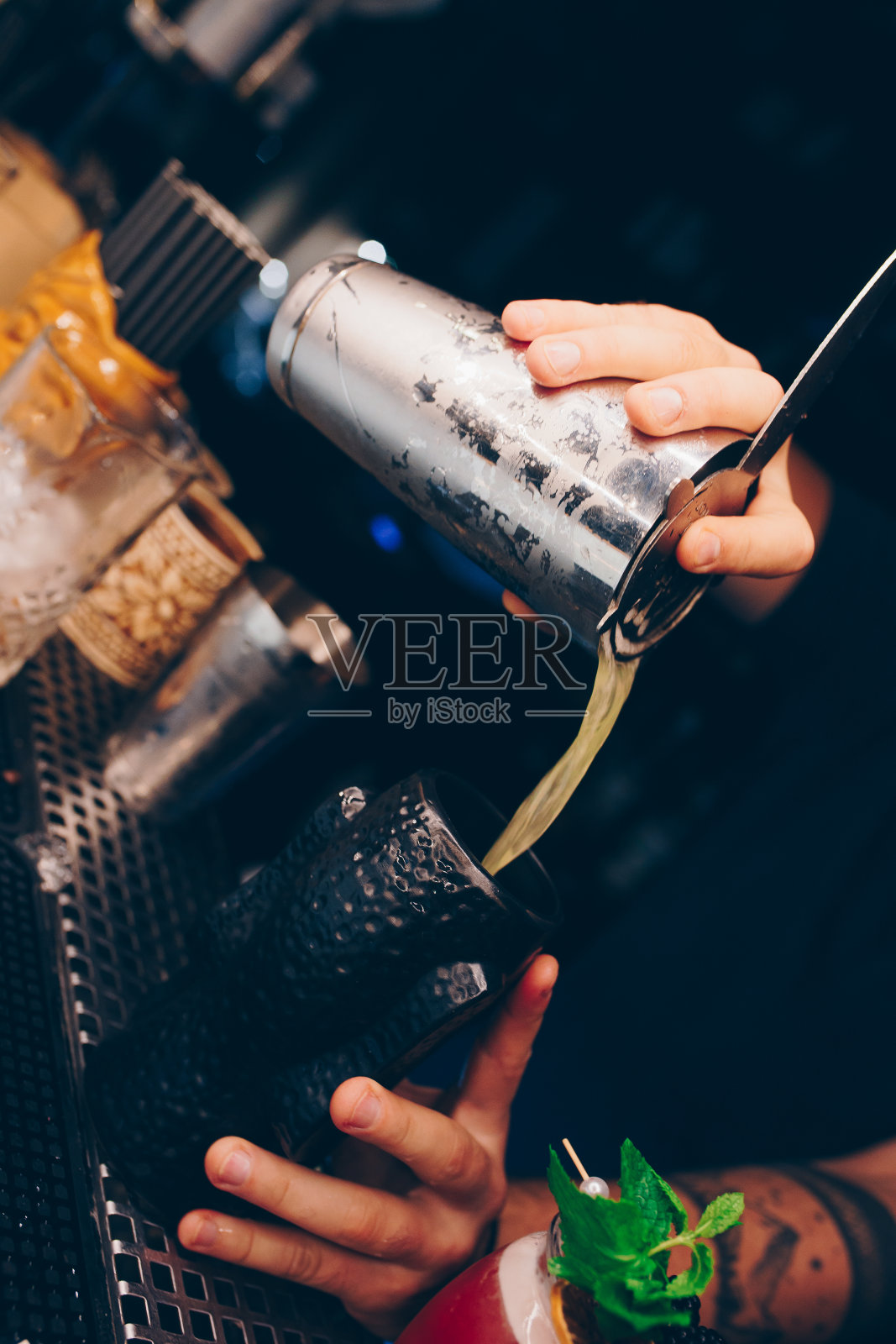 调酒师倒使用过滤白色健康鸡尾酒饮料在吧台上。专业的观点。时髦时髦的酒精饮料。夜总会的设计人员和豪华概念服务调酒师照片摄影图片