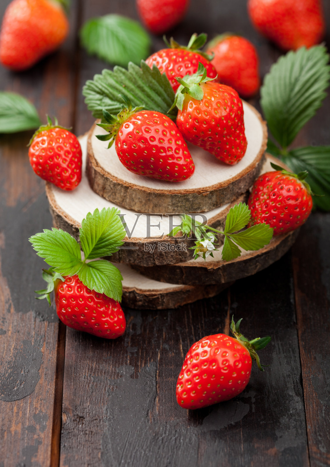 新鲜的生有机草莓与树叶在木板上木制背景。照片摄影图片